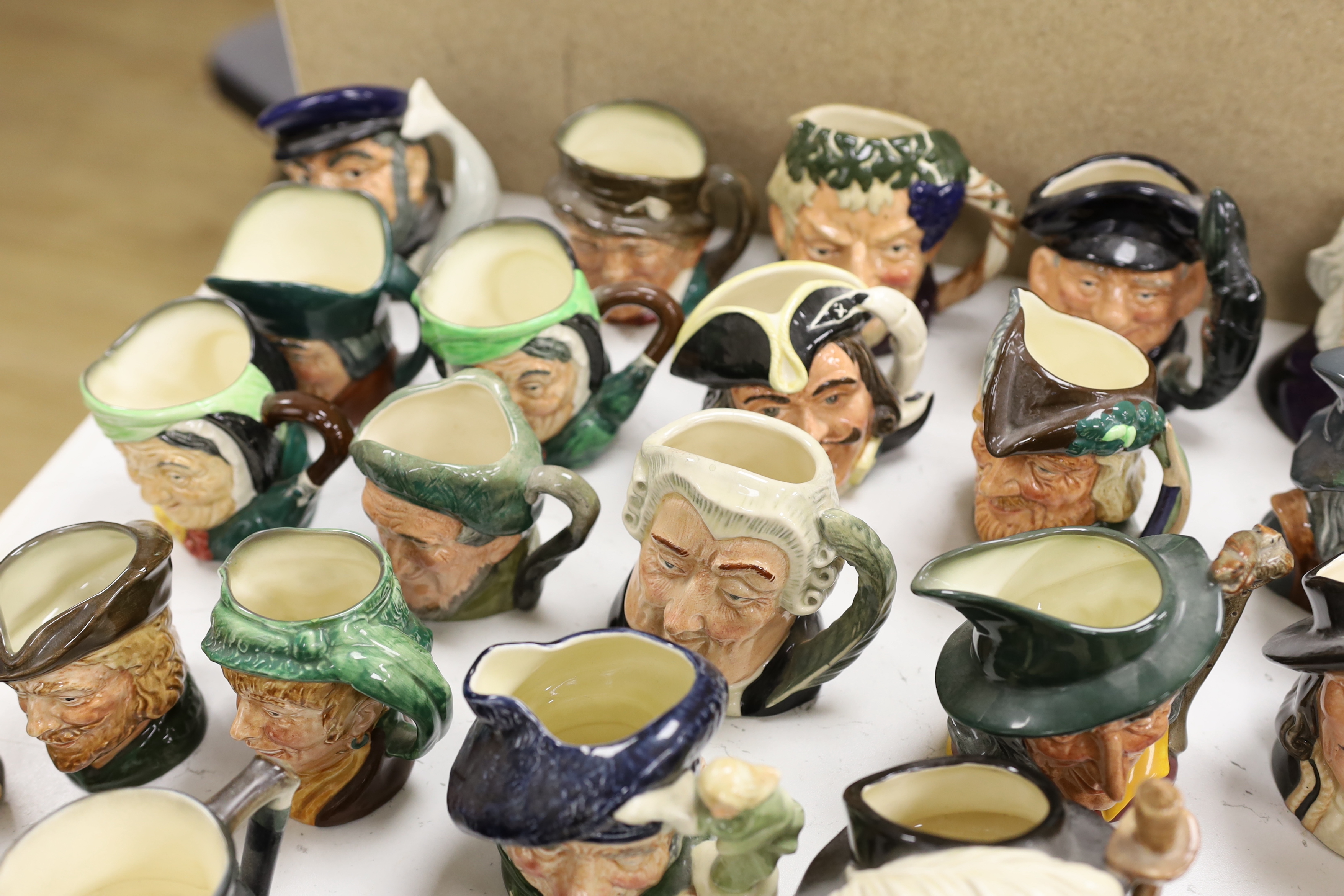 A large collection of Doulton character jugs including the Three Musketeers and Bacchus, largest 10cm high